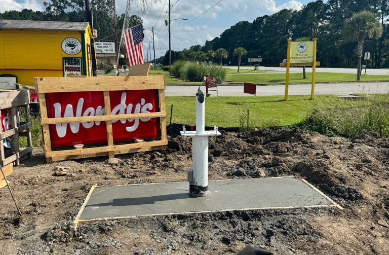 Concrete footer and post set for monument sign installation before structure placement