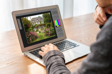 Real estate professional editing a property photo on a laptop to enhance lighting and color accuracy before listing