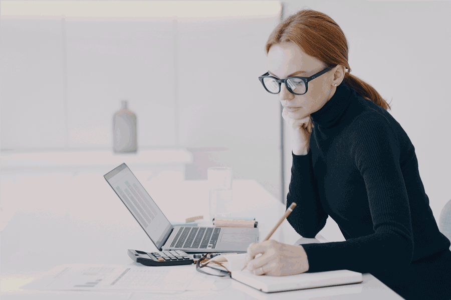 Real estate agent reviewing notes and writing marketing content at a desk, representing AI-assisted writing and messaging tools.