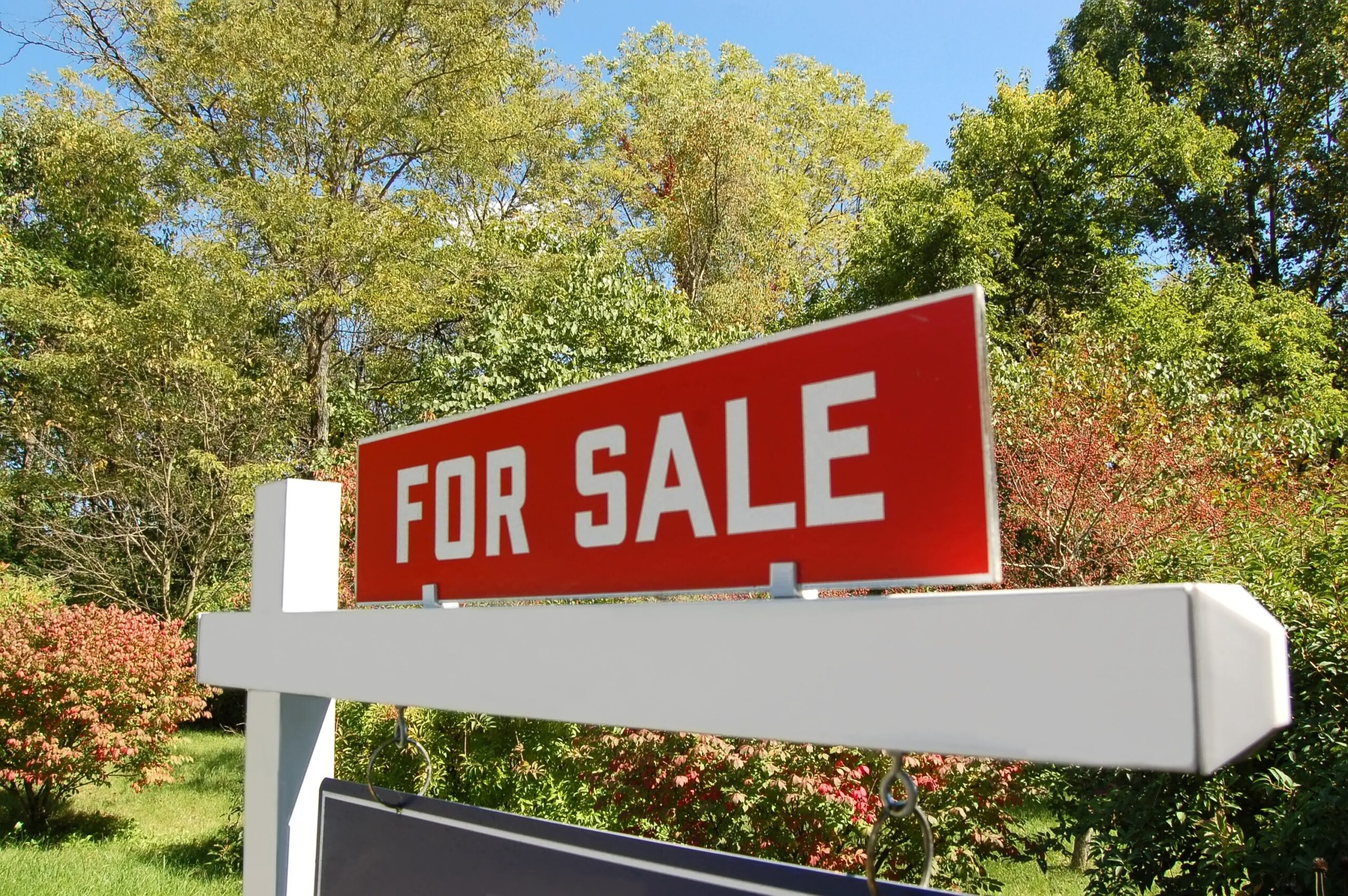 Real estate yard sign with clear, bold lettering demonstrating readable typography and simple design in a residential setting