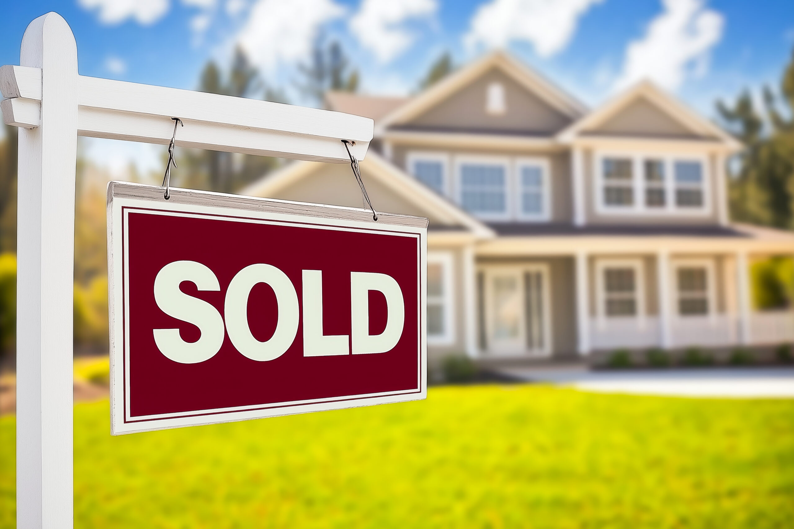 Real estate yard sign with sold rider in front of a suburban home, illustrating how sign design communicates success and targets the right audience