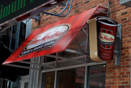 Digitally printed backlit awning illuminating a Tim Hortons storefront at night
