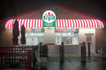 Illuminated storefront awning reinforcing brand visibility and nighttime presence for a commercial business