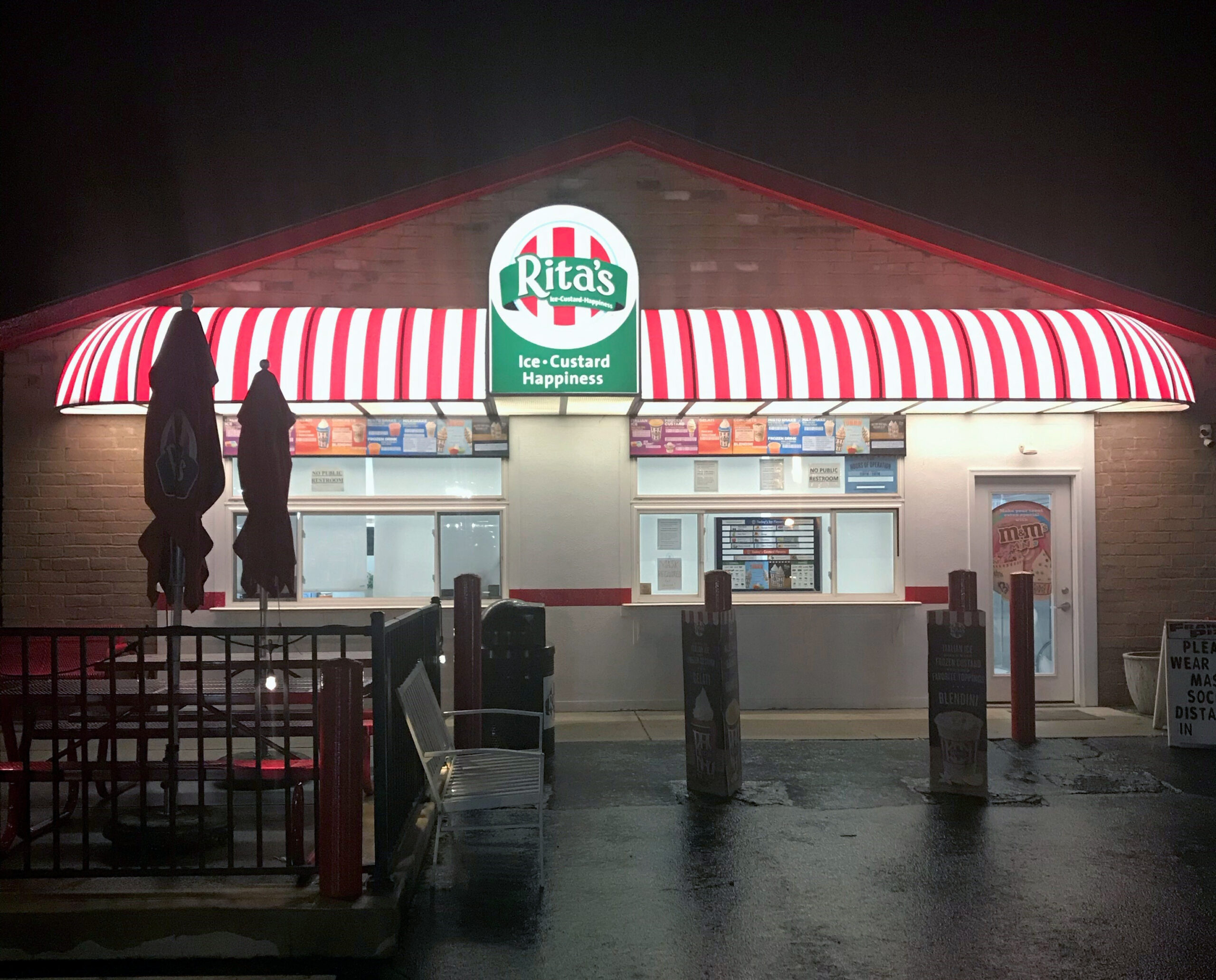Illuminated storefront awning reinforcing brand visibility and nighttime presence for a commercial business