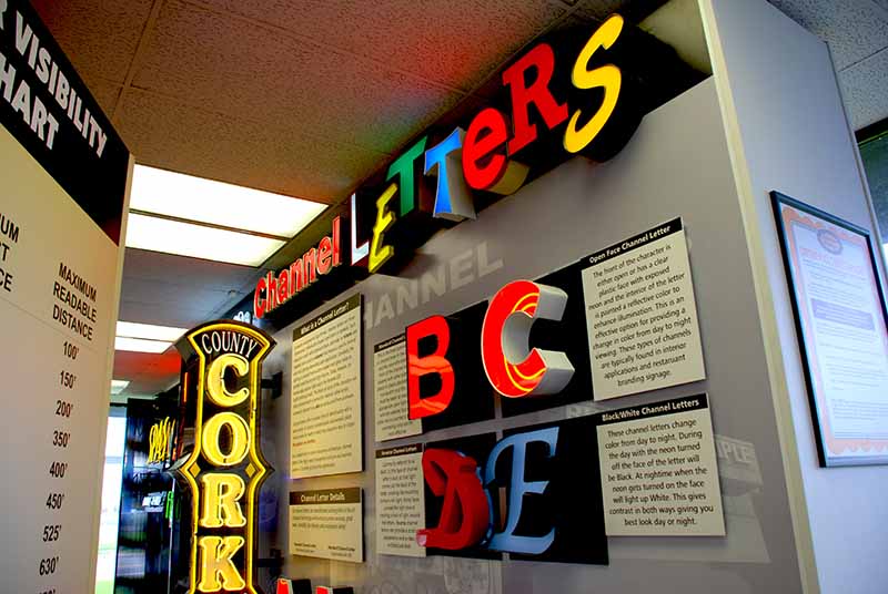 Channel letter display wall in Columbus showroom featuring face-lit, reverse-lit, and open-face letter examples