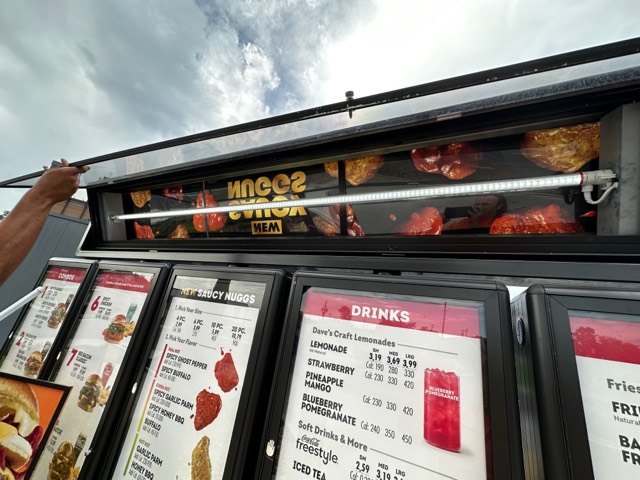 LED lighting retrofit installed inside commercial drive-thru menu board sign cabinet to improve energy efficiency and visibility.