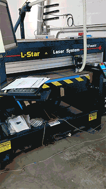 Industrial L-Star laser cutting system used in commercial sign fabrication and metal component production.