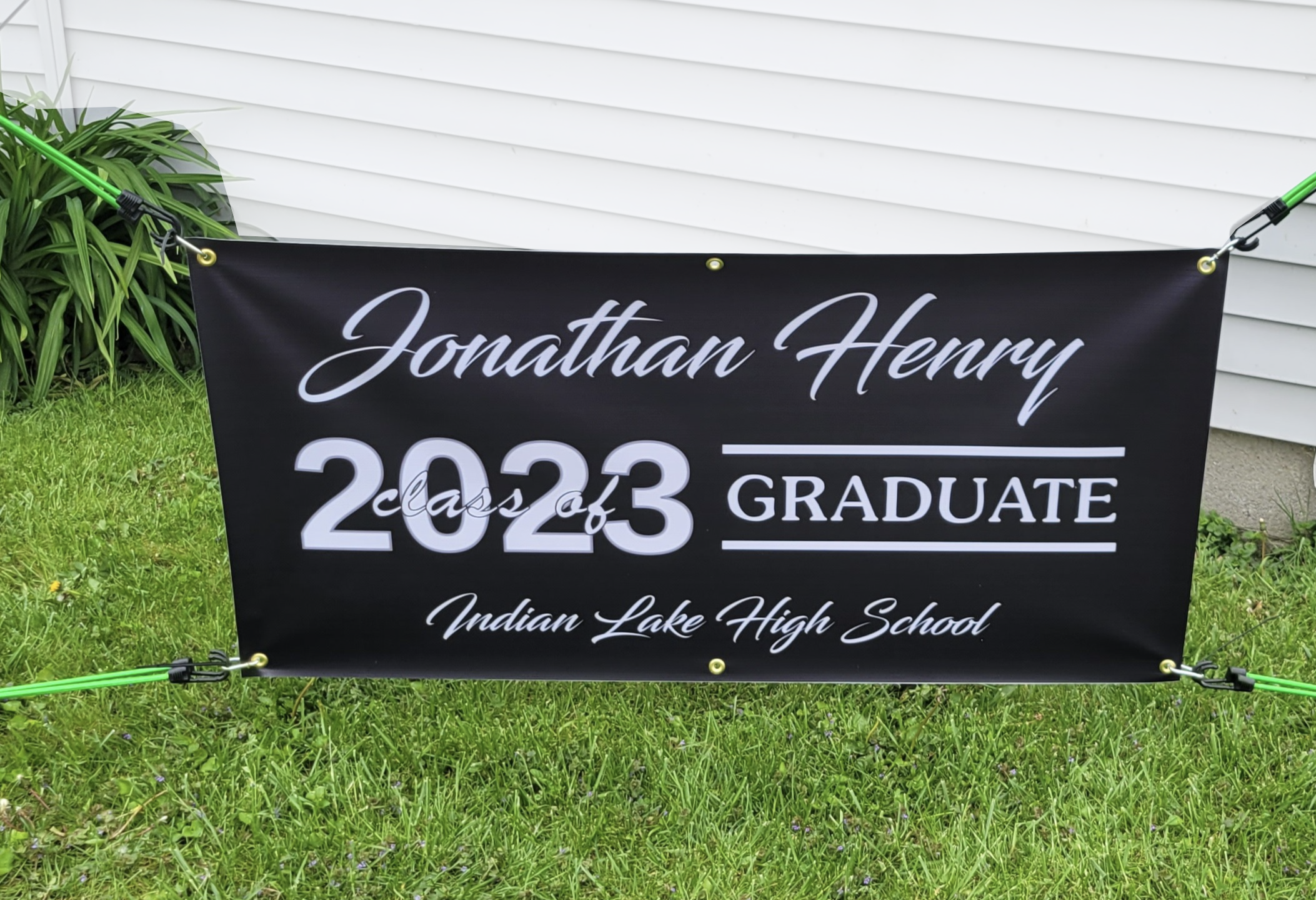 Black graduation banner with a clean, minimalist design featuring a graduate’s name, class year, and school